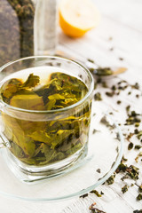 Cup of green tea and lemon and spoon on a wooden table