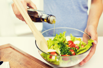 close up of woman cooking vegetable salad at home