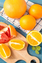 close up of fresh delicious oranges and grapefruit on an old wooden background
