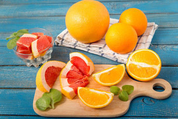 close up of fresh delicious oranges and grapefruit on an old wooden background