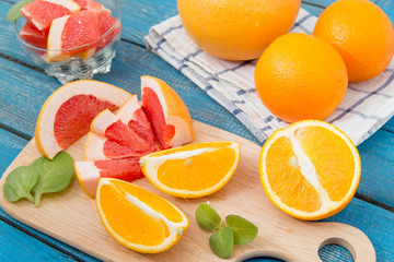 close up of fresh delicious oranges and grapefruit on an old wooden background