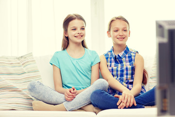 Fototapeta na wymiar two happy little girls watching tv at home