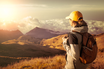 Woman with backpacker enjoying view at top in high mountains.