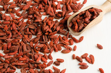Goji berry dried, with spoon, closeup background.