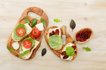 Fototapeta na wymiar Sandwiches with mascarpone, dried tomatoes, basil