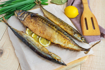 Baked sea fish (saury, mackerel) on wooden background.