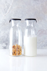 fresh homemade almond milk in a transparent bottle and almonds.
