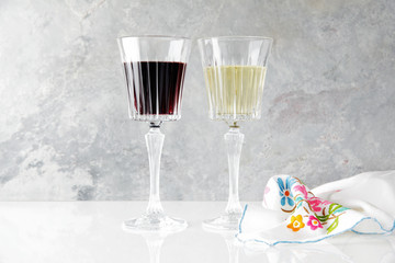 red and white wine in glasses on a white table