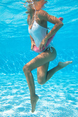 corps de femme sous l'eau qui fait de l'aquagym