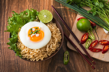 Instant noodles with egg in bowl and vegetable