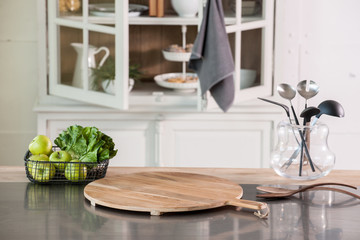 empty cutting board behind kitchen cupboard with metal kitchen countertop