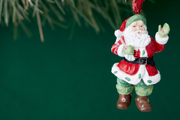 santa statue hanging on christmas tree.