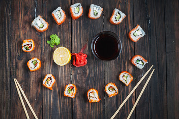 Obraz na płótnie Canvas Sushi roll with salmon on wood background. Top view