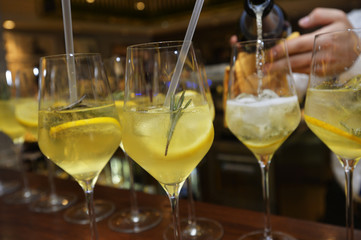 Barmen fills glasses of champagne cocktail