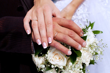 Obraz na płótnie Canvas Hands of the groom and bride with rings and bridal bouquet
