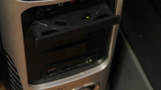 Hand holding New CD/DVD inside optical disk drive