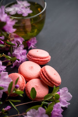Pink macaroons on the black wooden background