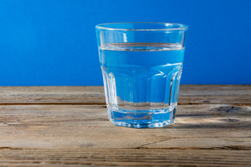 Glass of water on wooden background
