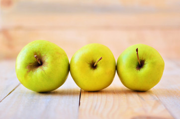 3 yellow apple on a wooden background