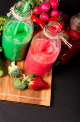 Fresh green, beetroot and carrot smoothie in the glass on black stone. Lifestyle concept