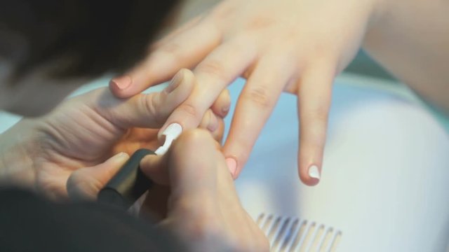 Woman making the manicure girl at the beauty salon