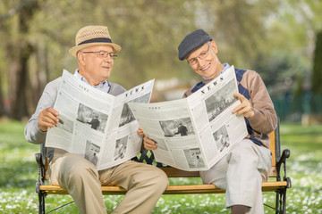 Seniors reading newspaper in a park