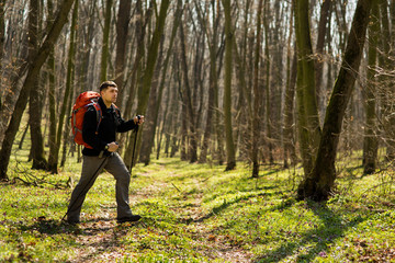 Male hiker looking to the side walking in forest