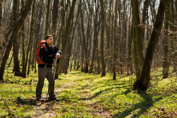 Obraz premium Male hiker looking to the side walking in forest