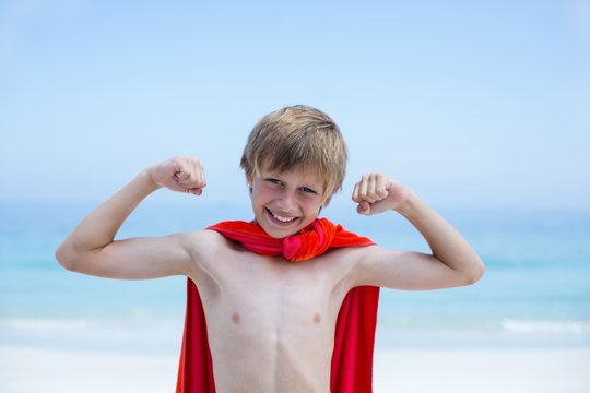 Happy shirtless boy wearing superhero costume