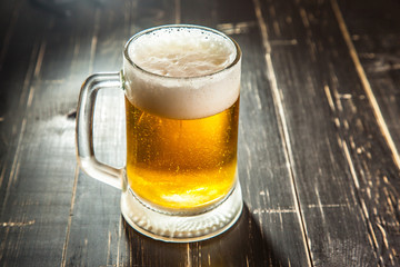 Mug of beer, on a wooden background