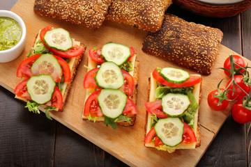 Vegetarian sandwich with pesto on wooden background