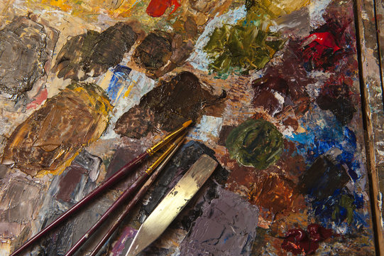 A variety of brushes for colored paints on the palette of the artist