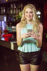 Smiling blonde woman using smartphone