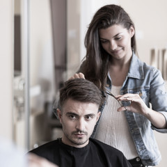Young hairdresser and male customer