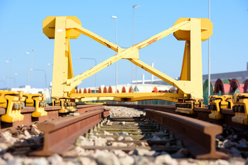 Bright yellow train buffer stop or bumper at the end of a railway track.