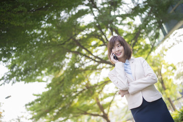 Naklejka premium Attractive asian business woman using on smartphone outside Offi