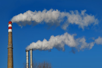 Chimneys smoke. Pipes emit long trail of smoke.