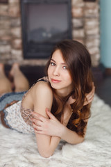 Beautiful woman lying by fireplace at home