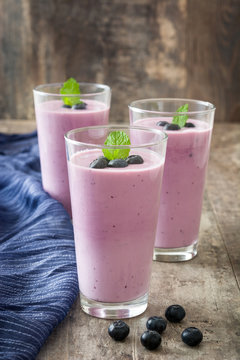 Blueberry smoothie in a glass on a rustic table
