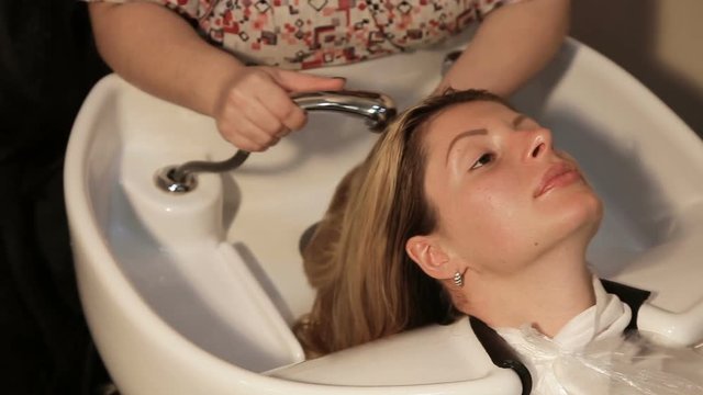 Hair care in modern spa salon. woman having her hair washed by a hairdresser at the hair salon.Woman washing head in spa salon.Spa treatments, beauty center.Barber washes the head of a beautiful girl