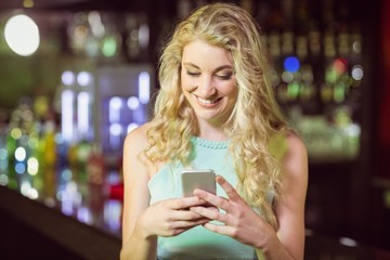 Smiling blonde woman using smartphone