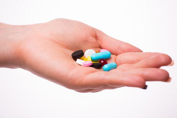 Pills, tablets, vitamins and drugs heap in woman hands, closeup view.