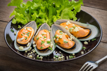 Baked mussels with garlic on plate