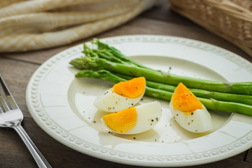 Boiled egg with asparagus on plate