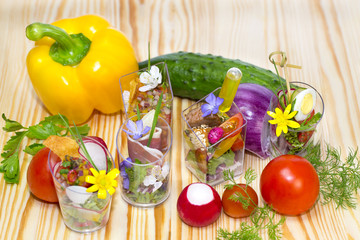 mini canapes in plastic cups decorated with edible flowers