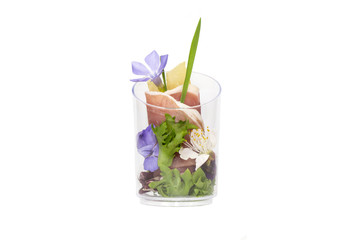 mini canapes in plastic cups decorated with edible flowers