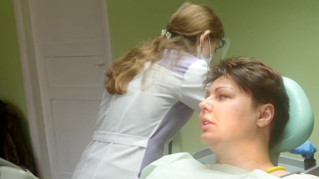 4k Young female patient receiving dental care from a dentist