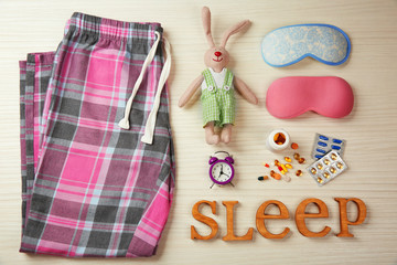 Insomnia concept. Sleeping accessories on light wooden table, top view