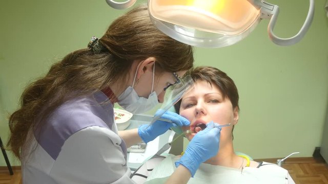 4k Close up footage of a dentist checking a woman for cavities