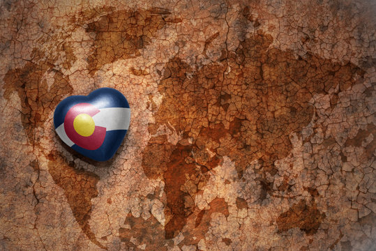 heart with colorado state flag  on a vintage world map crack paper background
